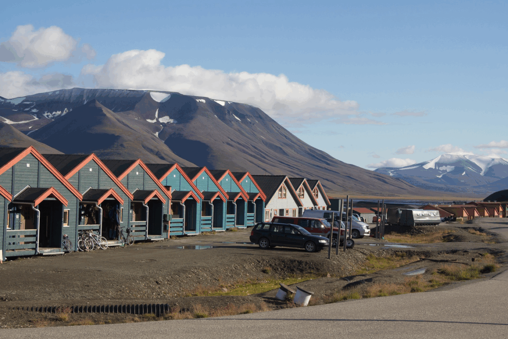 Huisjes in Longyearbyen met bergen op de achtergrond tijdens de zomer.